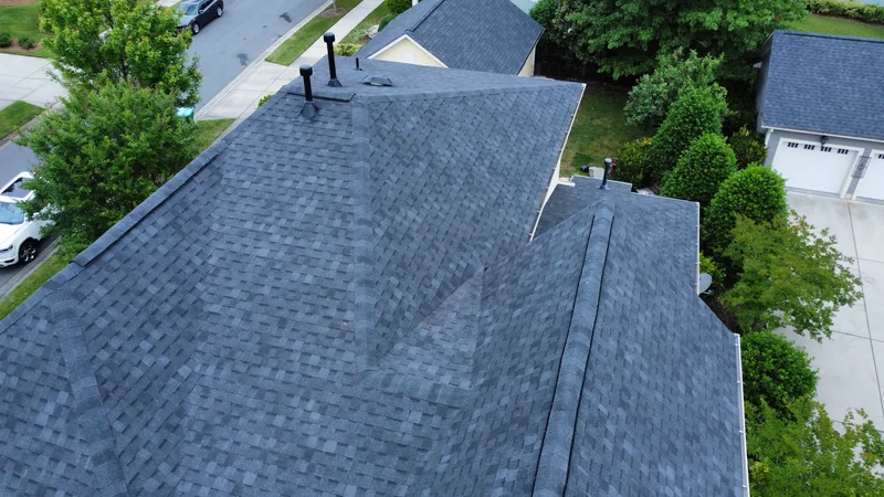 Drone view of a completed gray shingle roof with hips and valleys