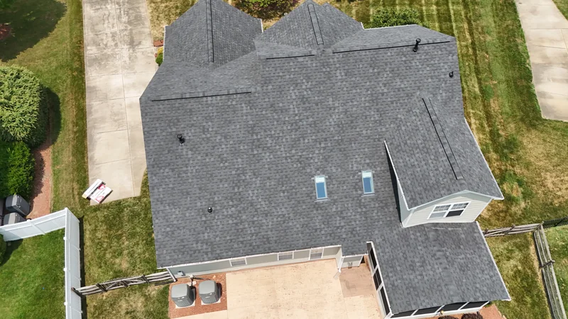 Overhead view of a gray shingle roof with two skylights