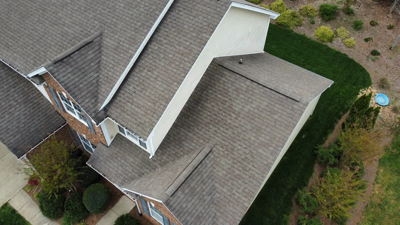 Aerial view of a tan shingle roof and white gables